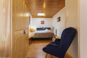 a bedroom with a bed and a blue chair at ArPaMond in Château-Chinon