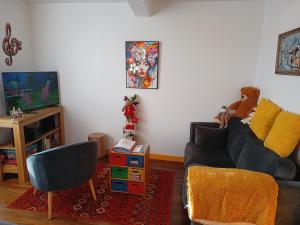 a living room with a couch and a tv at ArPaMond in Château-Chinon