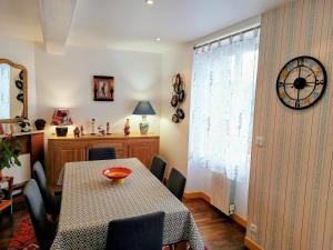 a dining room with a table and a clock on the wall at ArPaMond in Château-Chinon