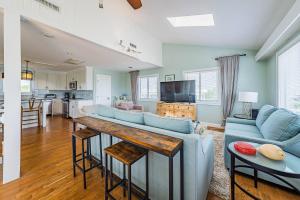 a living room with blue couches and a table at Arcadia - Duck, Caffey's Inlet, Ocean Views, 50 Yards to Beach, Pool, Pets OK, Cul-de-sac Location in Duck