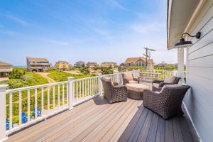 a balcony with wicker chairs and a view of the ocean at Arcadia - Duck, Caffey's Inlet, Ocean Views, 50 Yards to Beach, Pool, Pets OK, Cul-de-sac Location in Duck