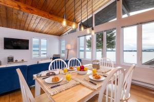 a dining room with a table with food on it at Hôtel à la maison - Cap à l'Ile in Les Éboulements +11 photos