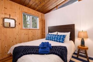 a bedroom with a bed with blue gloves on it at Hôtel à la maison - Cap à l'Ile in Les Éboulements