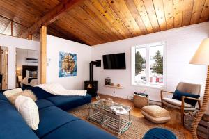a living room with a blue couch and a fireplace at Hôtel à la maison - Cap à l'Ile in Les Éboulements
