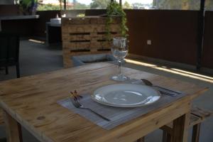 a plate and a wine glass on a wooden table at Nest & Rest in Sri Jayewardenepura Kotte