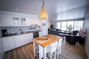 a kitchen and living room with a table and chairs at Lynghagi House in Vegamót