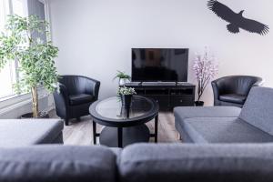 a living room with a couch and a tv at Lynghagi House in Vegamót