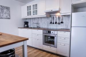 a white kitchen with white cabinets and a sink at Lynghagi House in Vegamót