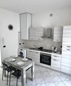 a kitchen with a table and chairs and a table and a microwave at A due passi dal Centro Intero appartamento con AC e WiFi in Forlì