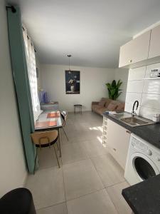 a kitchen and living room with a couch and a table at Heshima's Apartment for Business in Macouria