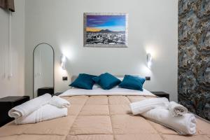 a bedroom with a large bed with blue pillows at ZapataRelais in Naples