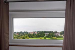a window with a view of a green field at Manhattan 516 mit Schwimmbad in Braunlage +20 photos
