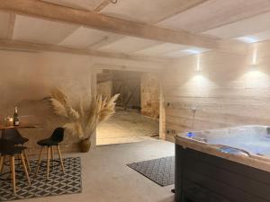 a bathroom with a tub and a table and chairs at A l'Ancienne Ferme in Steinseltz +112 photos