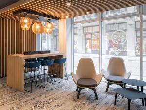 a lobby with a bar with chairs and a counter at B&B Hotel Leipzig-City in Leipzig