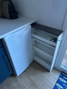 a white refrigerator with its door open in a kitchen at Studio cosy in Frontignan
