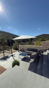 a patio with a table and an umbrella and chairs at Golden residence with heated pool in Vinišće
