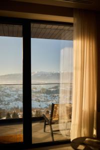 a room with a window with a chair and a view at The Pines Bucegi Lodge in Bran +288 photos