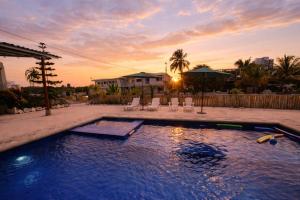 ein Swimmingpool in einem Hinterhof bei Sonnenuntergang in der Unterkunft Hosteria La Veleta, Playas in Playas