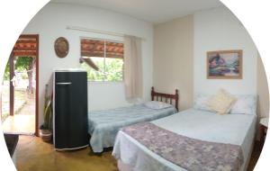 a room with two beds and a refrigerator at Recanto São Francisco de Assis in Pirenópolis