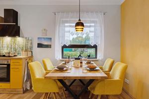 a dining room table with yellow chairs and a window at Ferienhaus Milchstraße mit Sternenblick in Lochow