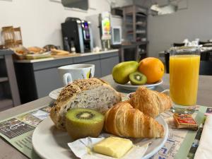 a plate of bread and croissants and a glass of orange juice at Logis Hotel Noemys Brive - Restaurant Le Teinchurier in Brive-la-Gaillarde