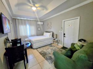 a living room with a bed and a couch at Cozy Green Apartment in Homestead