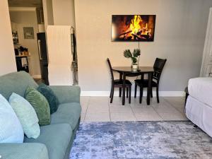 a living room with a couch and a table with a fireplace at Cozy Green Apartment in Homestead