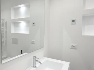 a white bathroom with a sink and a mirror at Palazzo Garbusi in Sarzana +62 photos