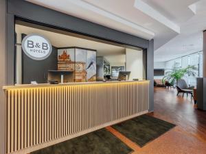 an office with a reception desk in a lobby at B&B HOTEL München-Schwabing in Munich