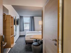 a small room with two beds and a table at B&B HOTEL München-Schwabing in Munich