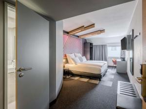 a hotel room with a bed and a room at B&B HOTEL München-Schwabing in Munich
