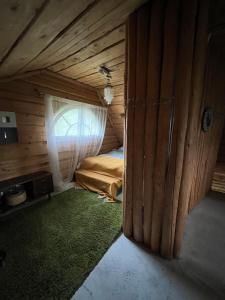 a small room with a bed in a wooden house at Privatus namelis gamtoje greta Trakų in Daugirdiškės