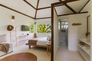 a white bedroom with a bed and a window at Beco das Flores in Mata de Sao Joao