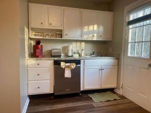 a kitchen with white cabinets and a stove with a towel at Hillside Haven - affordable and convenient in Chattanooga