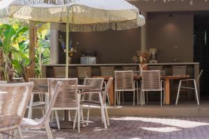 a restaurant with chairs and a table and an umbrella at Beco das Flores in Mata de Sao Joao