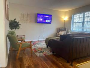 a living room with a couch and a tv on the wall at Hillside Haven - affordable and convenient in Chattanooga