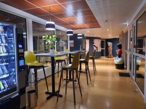 a bar with yellow chairs and a table in a store at La Villa des Golf.e.s in Theix