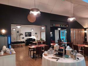 a dining room with tables and chairs and a room with at La Villa des Golf.e.s in Theix +52 photos