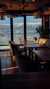 a restaurant with tables and chairs and a view of the mountains at The Pines Bucegi Lodge in Bran