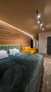 a bedroom with a large bed and a yellow couch at SarySai Boutique Hotel in Almaty