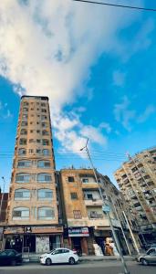 two tall buildings with cars parked in front of them at Solitaire Plaza Hotel-Ismailia سولتير بلازا الاسماعلية in Ismailia
