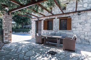 a patio with a table and chairs in front of a building at Pelion Villa Serenity View in Pouríon