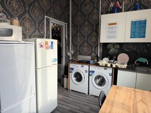 a kitchen with a refrigerator and a washer and dryer at Pulse capsule hotel in Almaty