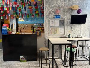 a bar with two tables and stools in a room at Pulse capsule hotel in Almaty