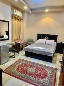 a bedroom with a bed and a television and a rug at Solitaire Plaza Hotel-Ismailia سولتير بلازا الاسماعلية in Ismailia