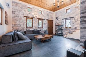 a living room with a stone wall at Pelion Villa Serenity View in Pouríon
