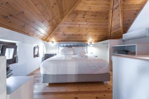 a bedroom with a bed with a wooden ceiling at Pelion Villa Serenity View in Pouríon