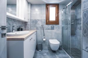 a bathroom with a toilet and a sink and a shower at Pelion Villa Serenity View in Pouríon +40 photos