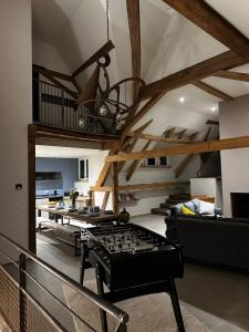 a living room with a ping pong table and stairs at A l'Ancienne Ferme in Steinseltz