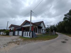 a small house on the side of a road at NikNa Homestay Batu Rakit - WIFI Netflix in Kampong Ru Tujoh